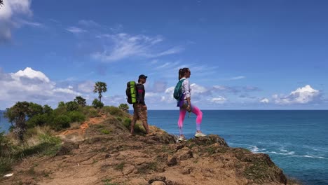 couple hiking on coastal cliff with ocean view
