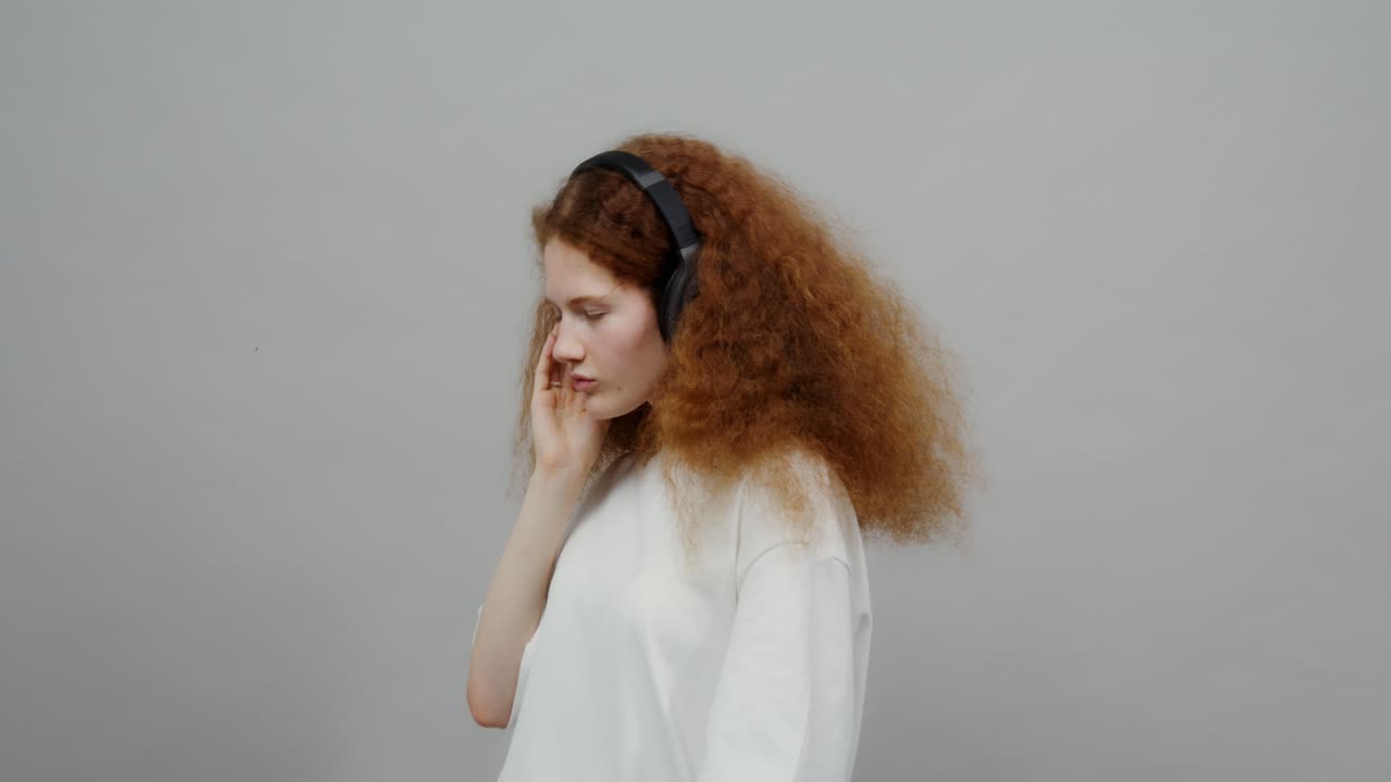 una mujer joven bailando con auriculares.