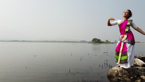 a bharatnatyam dancer displaying a classical bharatnatyam pose in the nature of vadatalav lake, pavagadh