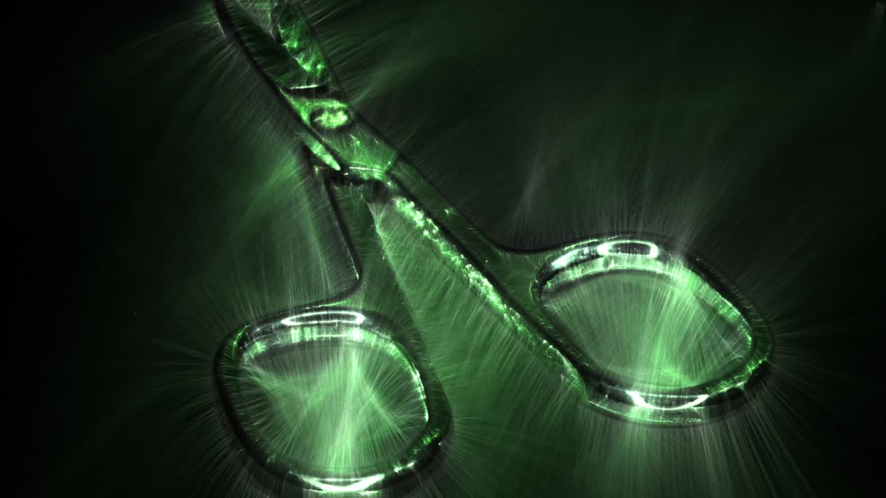 vista del aura de kirlian en bucle de pequeñas tijeras de metal girando.