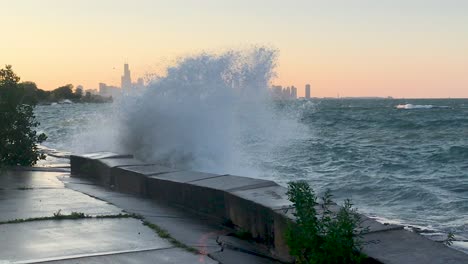 lake michigan waves crashing with chicago skyline in evening in slow motion