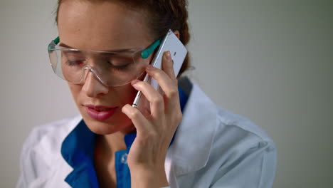 Mujer-Investigadora-Hablando-Por-Teléfono-Móvil.-Investigadora-En-Gafas-De-Laboratorio