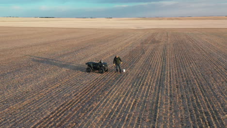 agricultor con quad en el campo de la granja muestreo de suelo para pruebas, tiro de círculo aéreo