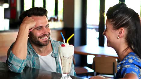 Happy-couple-interacting-while-having-milkshake