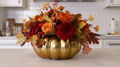 autumn floral arrangement in golden pumpkin vase