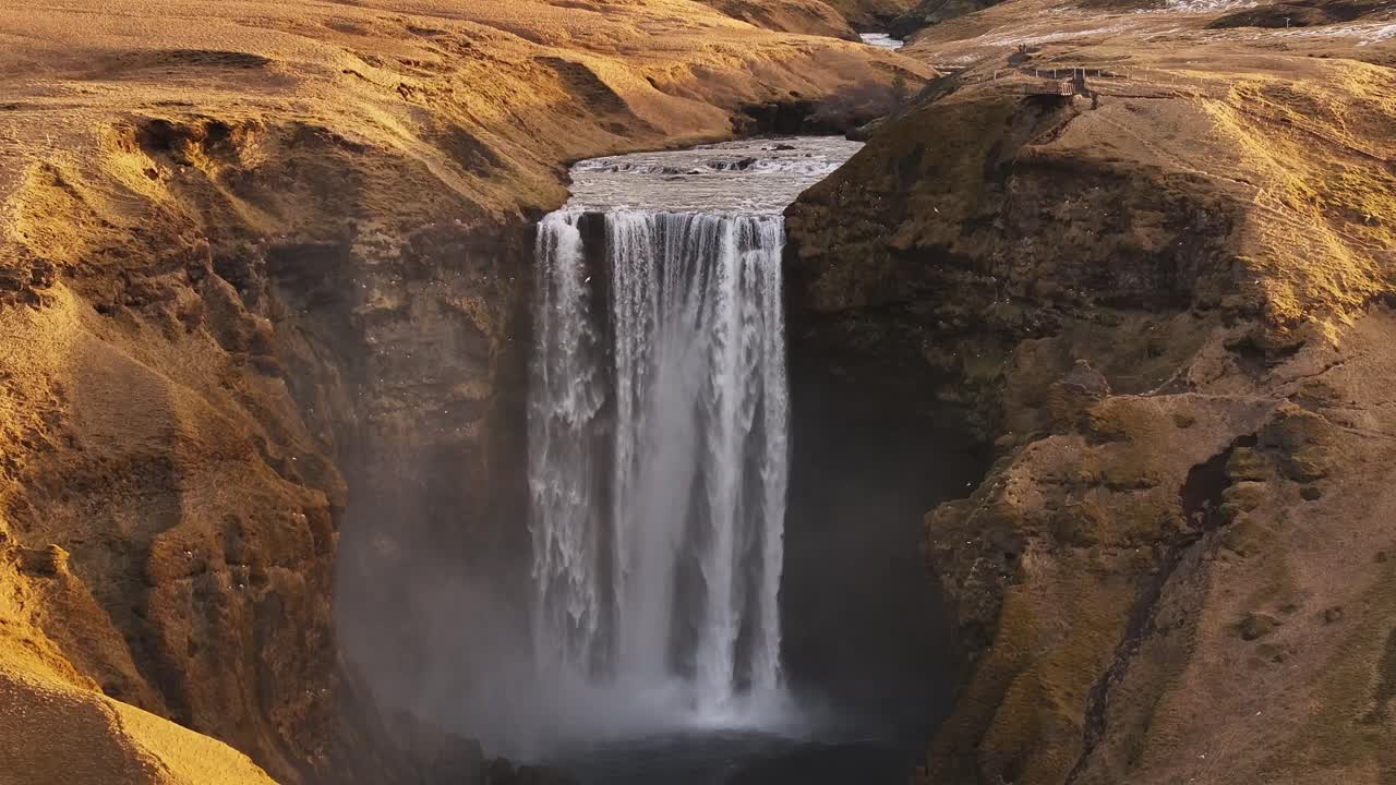 aerial - Skógafoss waterfall crashing into canyon in south Iceland