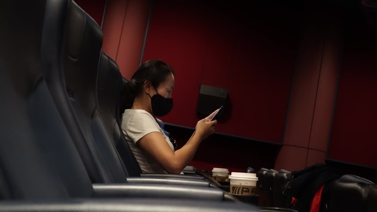 mujer asiática pasando tiempo sola en un cine vacío