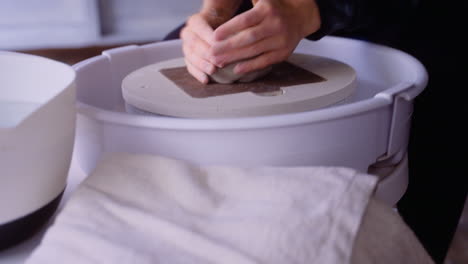 Potter-shaping-clay-in-her-hands-and-on-a-pottery-wheel