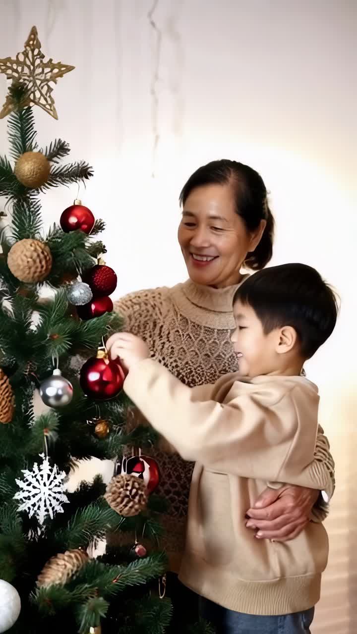 Asian grandmother with her grandson decorating a Christmas tree