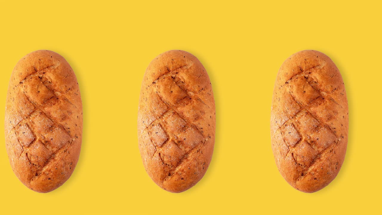 seamless animation of a whole diet loaf of bread top view above a yellow background, copy space