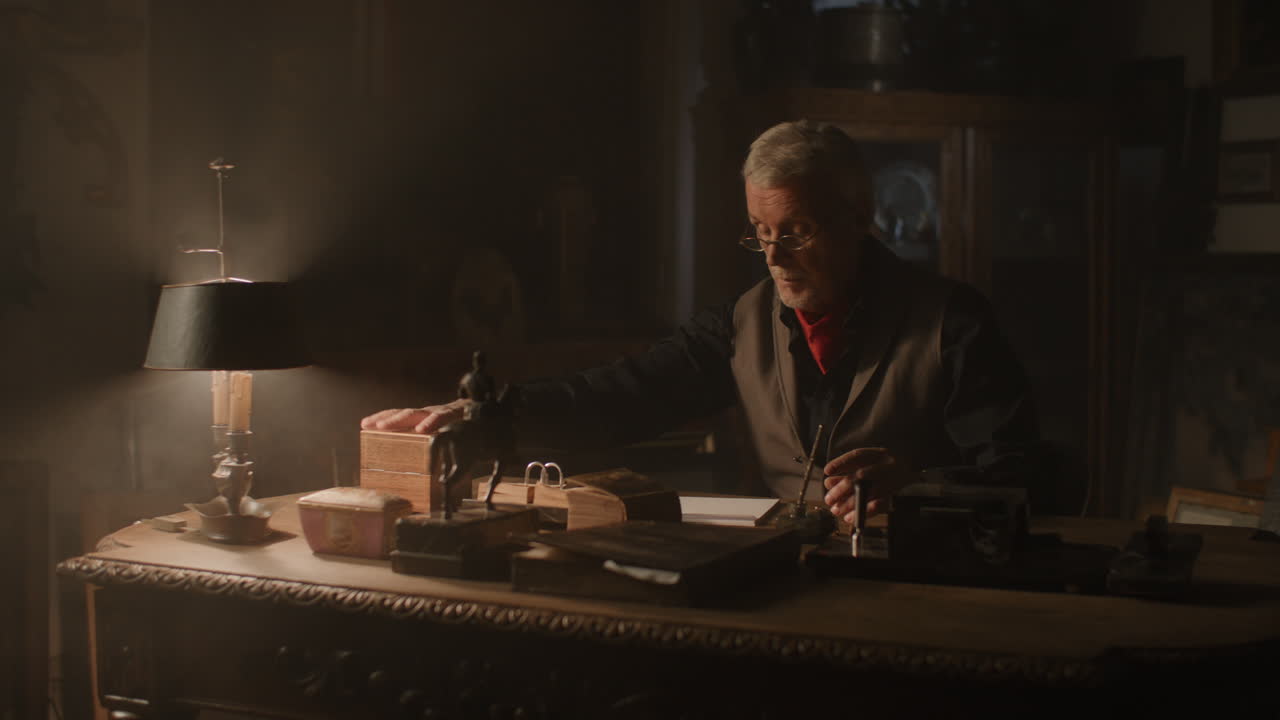 Older passionate antique dealer puts an old watch to the wooden box