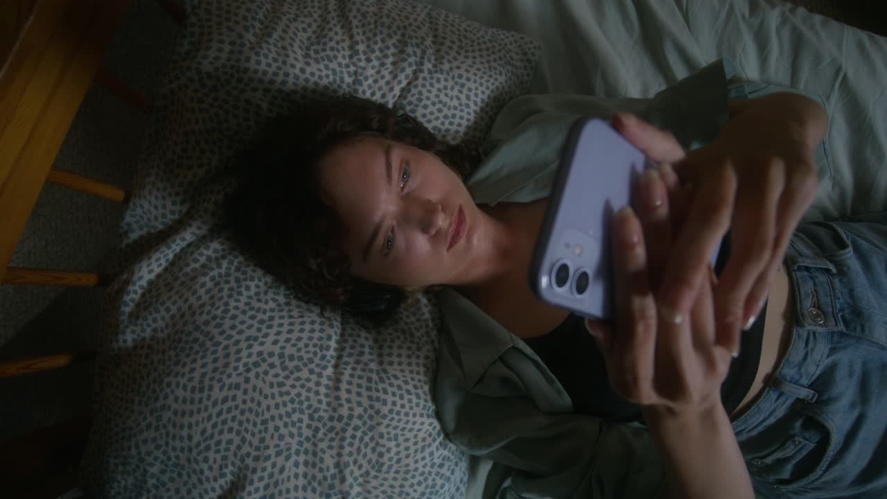 Woman Lying in Bed Using Smartphone