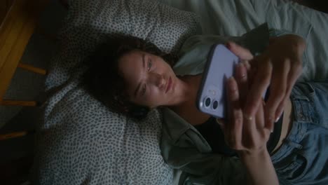 mujer acostada en la cama usando un teléfono inteligente