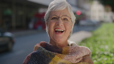 portrait of happy elderly woman laughing cheerful enjoying successful retirement lifestyle on sunny urban day in city street wearing scarf confident retired middle aged female slow motion