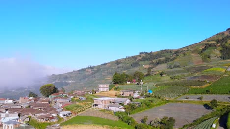 Blick-Aus-Der-Vogelperspektive-Auf-Die-Sonnigen,-Terrassierten-Berghänge-Des-Ländlichen-Indonesiens