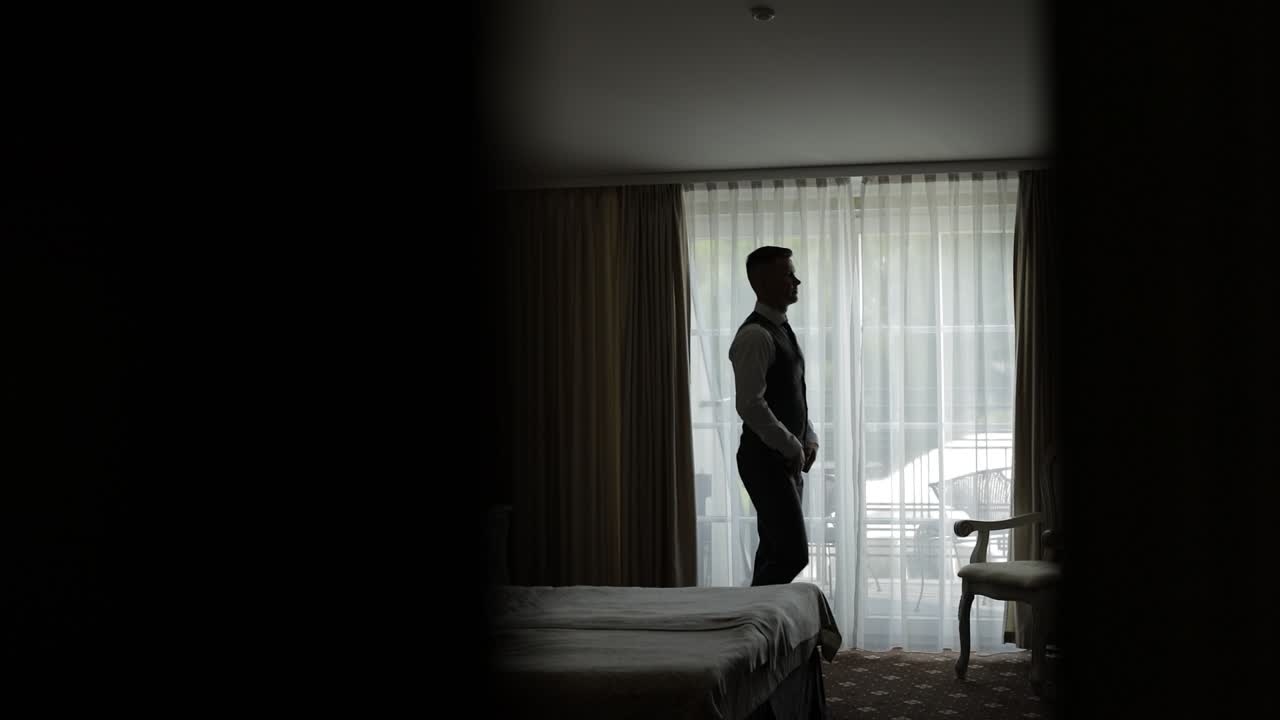 신랑이 호텔 방에서 준비하고 있습니다.