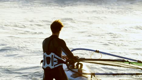 surfista masculino haciendo windsurf en la playa 4k