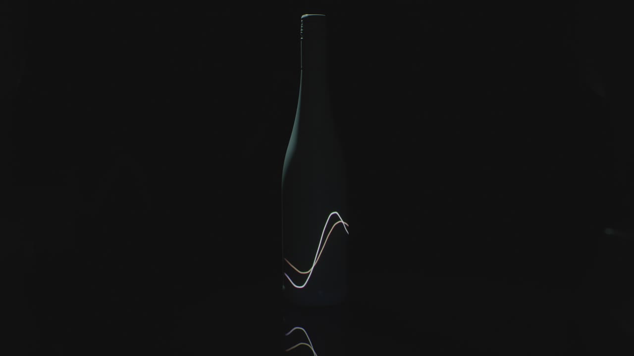 las ondas de luz brillan en una botella de vino oscura