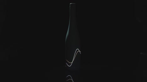 light waves shine on a dark wine bottle