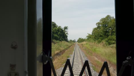 pov shot from train of thailand's eastern line from bangkok to ban klong luk during the day in thailand, close up shot