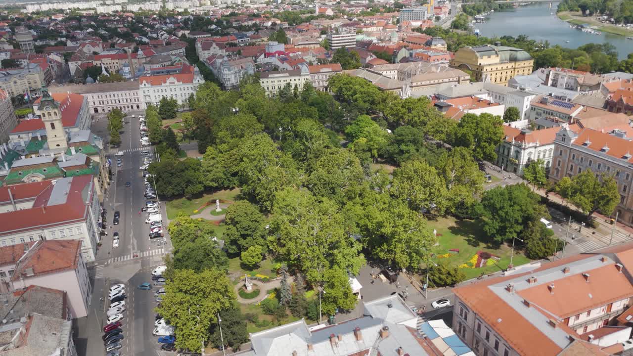Aerial over Szeged’s Széchenyi Square, highlighting vibrant green spaces alongside historic buildings