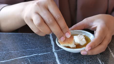 una mujer comiendo pan con un salto