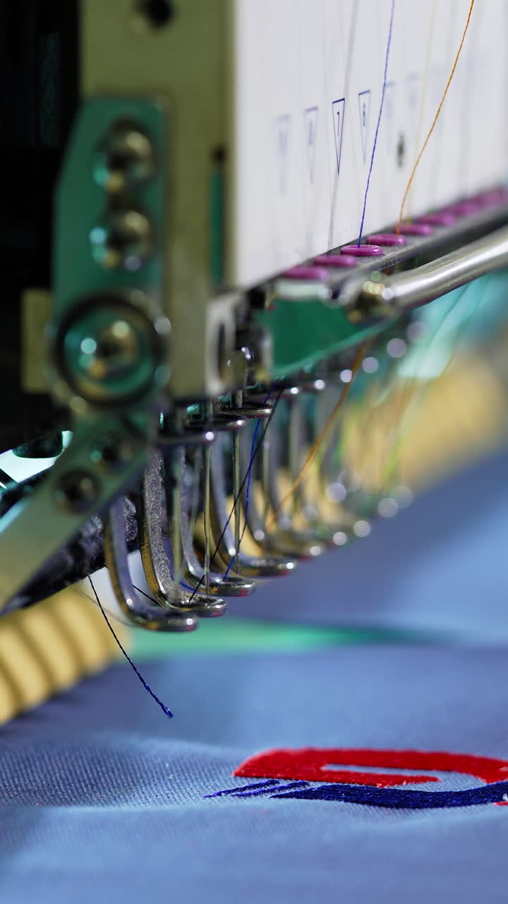Needle of a sewing machine makes a thread stitches. Sewing needle of automatic sewing machine moving rapidly. Close-up. Vertical video