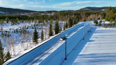 car driving on snowy road through winter forest in skorped, sweden, clear day