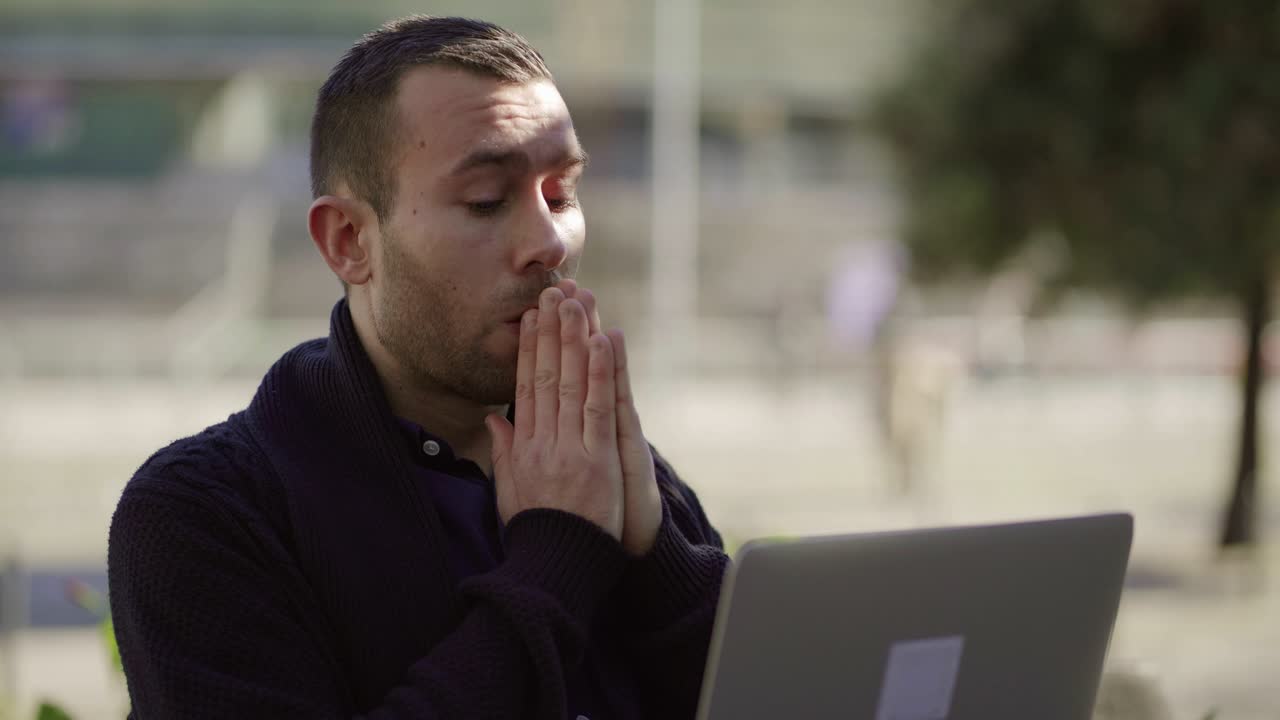 Jovem marketólogo exausto trabalhando com laptop.