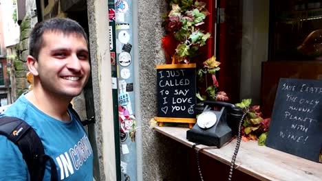 young attractive happy man picks traditional telephone while sightseeing