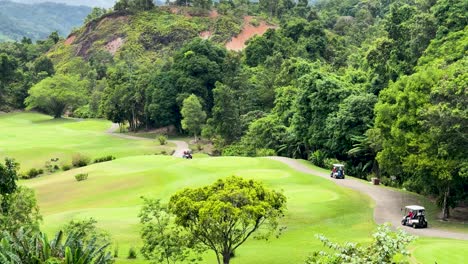 golf carts navigating lush green course in phuket, thailand