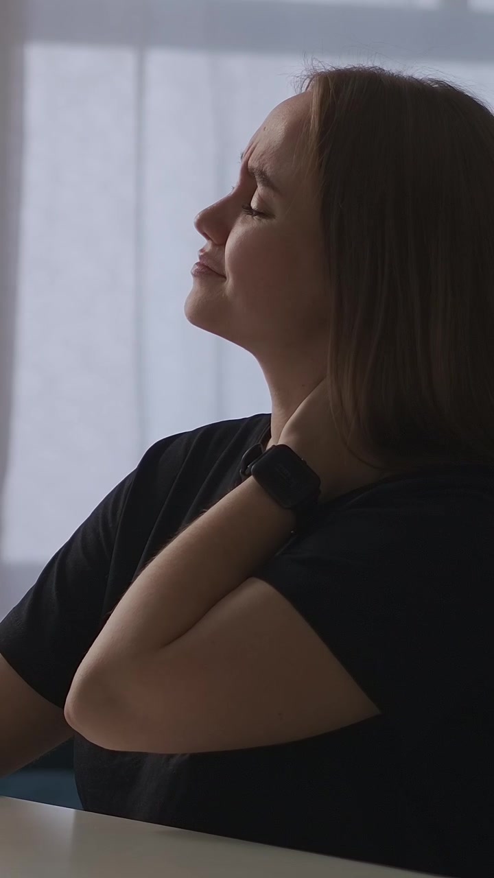 Giovane donna con dolore al collo che si massaggia la nuca