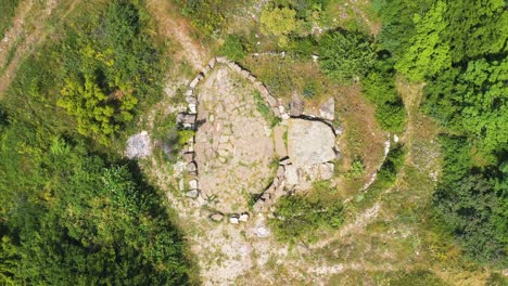 flying up above dolmen on top of muntain. high angle aerial view