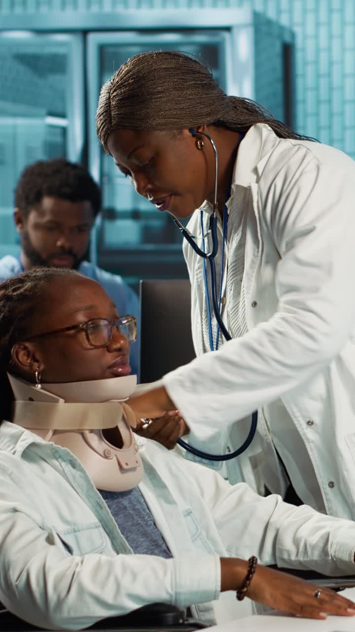 Female Doctor Examines Patient in Wheelchair Wearing Neck Brace