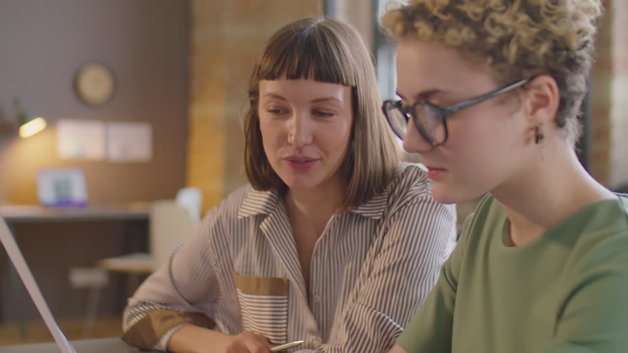 Woman with Prosthetic Arm Discussing Business Papers with Colleague