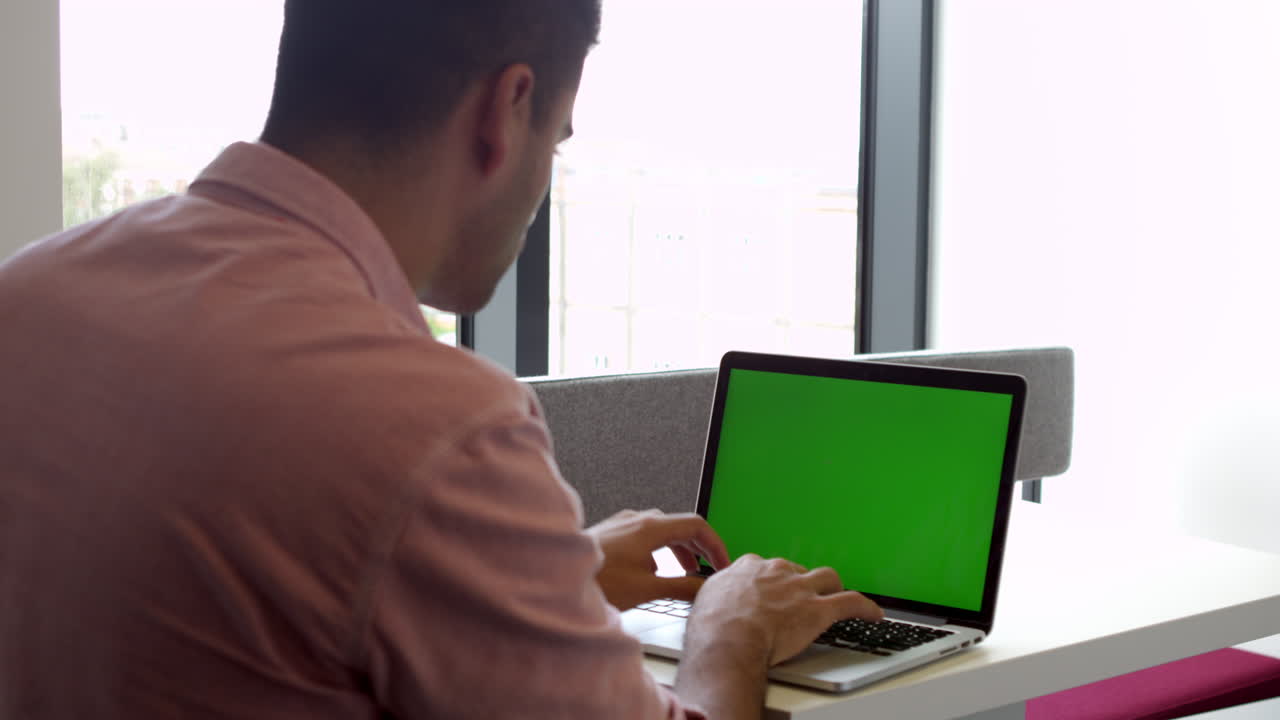 vista desde atrás de un estudiante masculino usando un portátil filmado en r3d