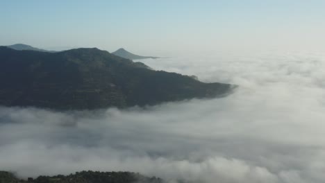 scenery of misty mountains with sea of clouds in sardinia island, italy. - aerial shot