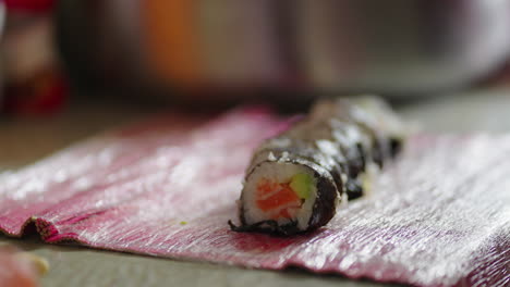 homemade salmon sushi rolls with avocado cut into bite-sized portions. - closeup shot