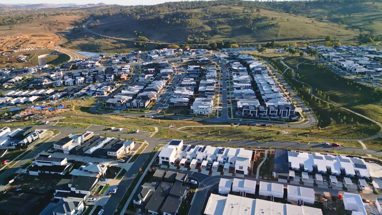 Drone captures a growing Canberra suburb with rows of homes and vast areas of undeveloped land awaiting future housing.