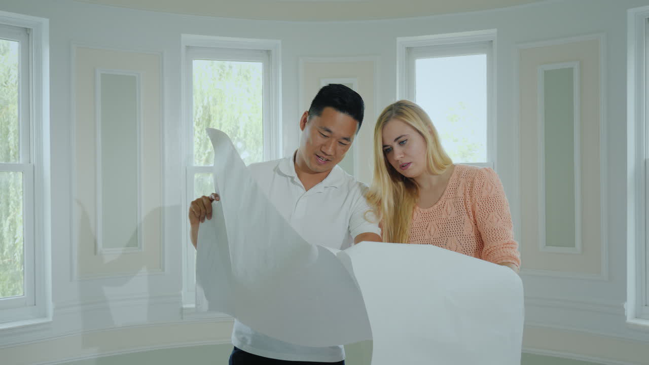 dos jóvenes arquitectos están estudiando un plan para construir un nuevo apartamento dentro de una nueva casa ligera