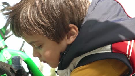 Slow-motion-footage-of-caucasian-kid-checking-his-bike-before-the-ride,-close-up-shot