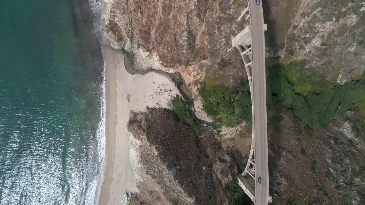Vídeo Aéreo de Drone da Rodovia da Ponte Bixby com água e costa abaixo em Big Sur Monterey, Califórnia