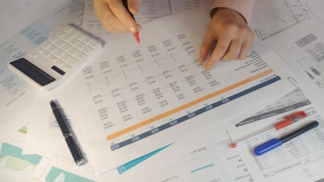 hand of accountant is counting financial report on calculator closeup