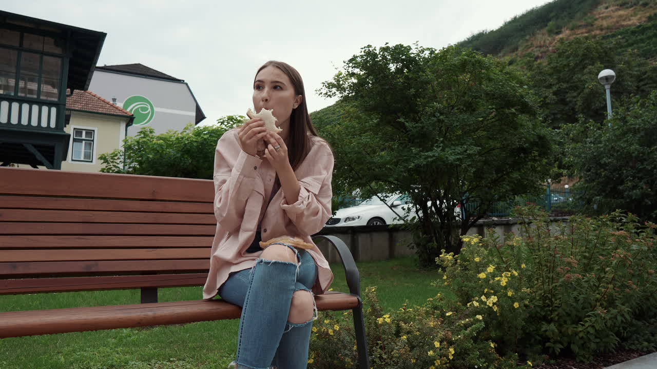 공원에서 샌드위치를 먹는 여자