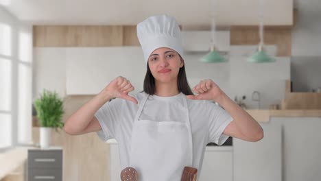 una mujer india molesta chef profesional pulgares hacia abajo