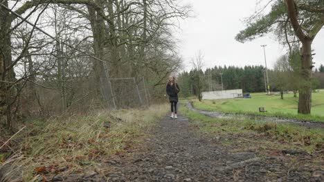 a young girl out on a winter afternoon in the uk walking at the local park