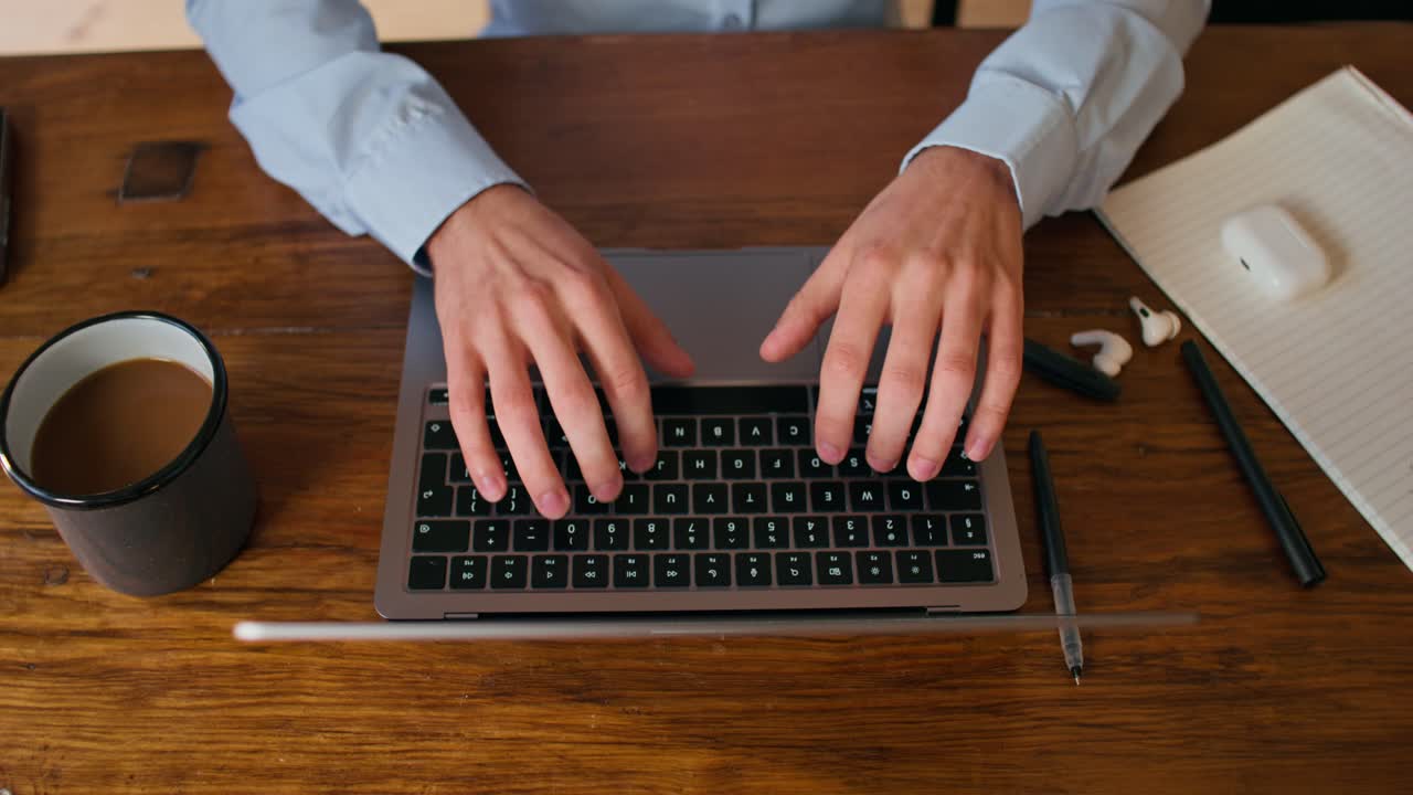 persona trabajando en una computadora portátil en una mesa de madera