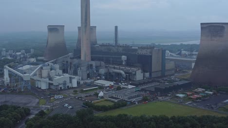 Imposing-concrete-cooling-tower-power-station-farmland-countryside-aerial-view-closeup-zoom-out