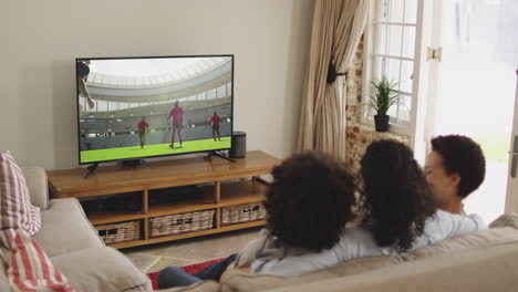 composite of happy family sitting at home together watching rugby match on tv