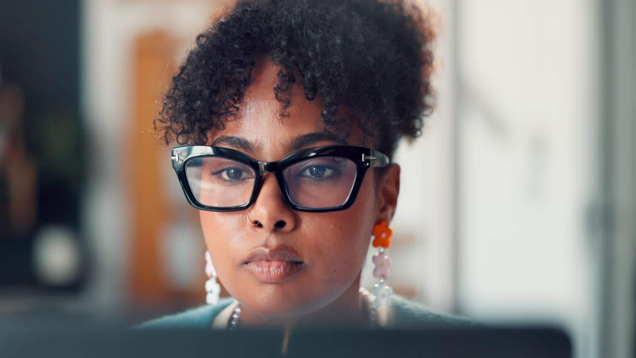 Close-Up of a Focused Young Black Woman Working on a Computer Screen